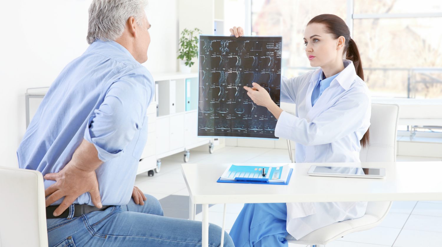 female orthopedist examining senior man clinic What is osteoporosis ss FEATURE